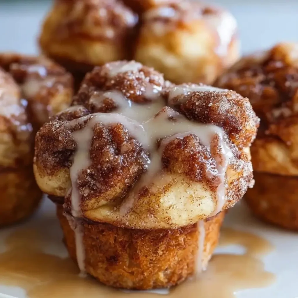 Gooey monkey bread muffins fresh from the pan, coated in sticky brown sugar glaze, cinnamon, and optional chopped pecans.