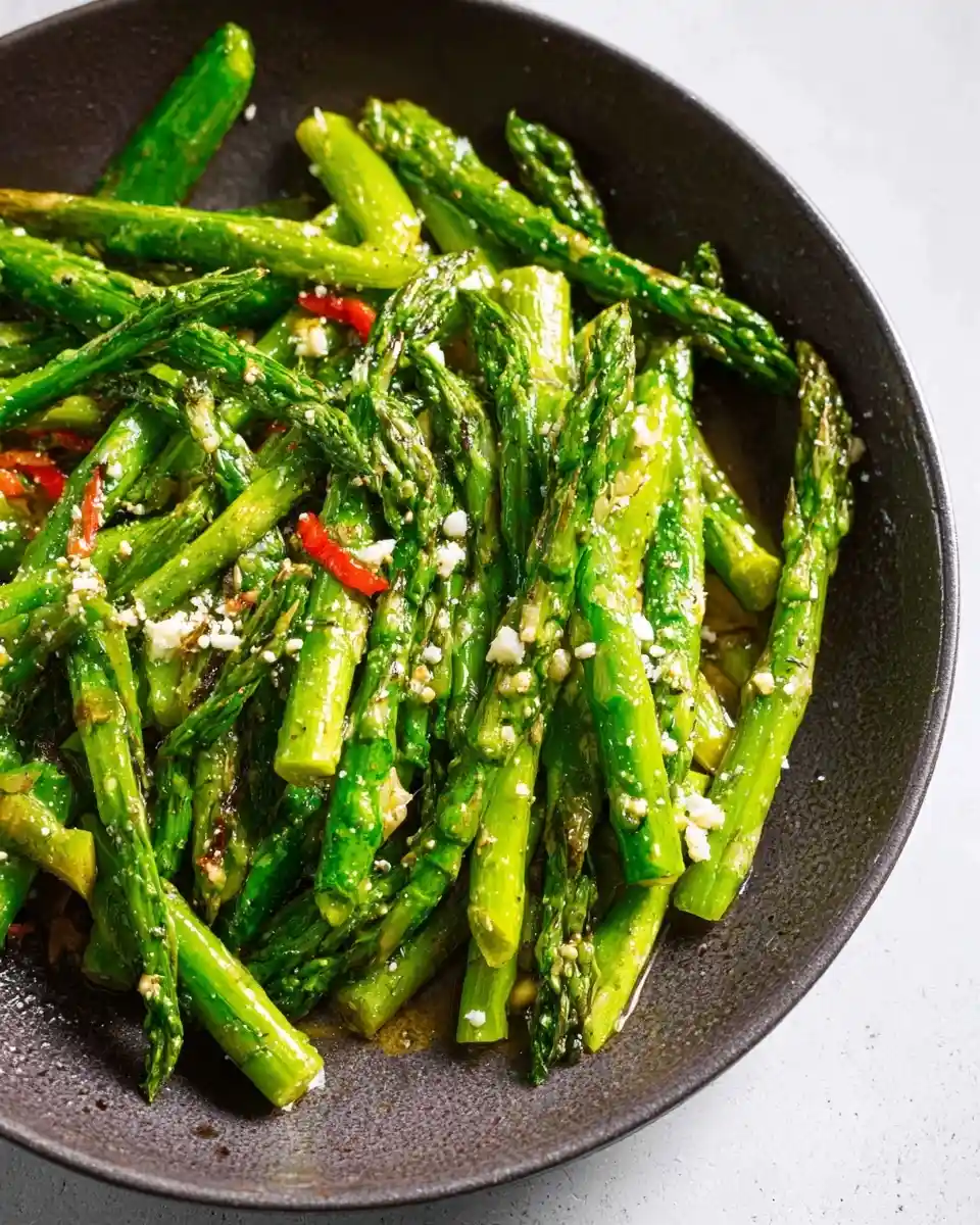 Vibrant {{ $('Fetch Recipe Data').first().json["Main Keyword"] }} garnished with cheese crumbles and chili flakes in a dark bowl.